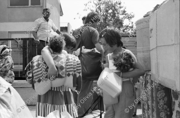 Image of sheet 19890600 photo 33: 34. Tag des Exodus türkischstämmiger 'Ausflügler', wie sie in Bulgarien genannt werden. Deportierte in der Türkei. Lastwagenschlage an der Türkisch-Bulgarischen Grenze. Auf dem Bahn-Quai von Kapikule sitzen und liegen hunderte von Türkischstämmigen BulgarInnen mit ihren Familien erschöpft in einem grossen elenden Durcheinander. Die Türkische Fahne bedeutet für viele das Symbol eines 'freien' Landes. In Bulgarien hat man sie gezwungen ihre Namen und ihre Sprache zu ändern. Oezal benützt die ca 300'000 Bulgaren für seine Wahlkampagne. Viele Kinder weinen unaufhörlich vor Erschöpfung. In Bergen von Hab und Gut entdecke ich ganze Wohnungseinrichtungen. Der Duty Free Laden ist geschlossen. Die Güterwagen, in denen die Menschen tagelang eingesperrt reisen mussten, werden nach ihrer Leerung wieder zurückfahren und noch mehr Familien in ihr Unglück stürzen. Türkei Turkey Bulgarian Refugees 1989