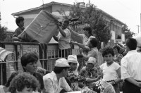 Image of sheet 19890600 photo 37: 34. Tag des Exodus türkischstämmiger Flüchtlinge aus Bulgarien, Kapikule Türkei 1989.

Deportierte in der Türkei. Lastwagenschlage an der Türkisch-Bulgarischen Grenze. Auf dem Bahn-Quai von Kapikule sitzen und liegen hunderte von Türkischstämmigen BulgarInnen mit ihren Familien erschöpft in einem grossen elenden Durcheinander. Die Türkische Fahne bedeutet für viele das Symbol eines 'freien' Landes. In Bulgarien hat man sie gezwungen ihre Namen und ihre Sprache zu ändern. Oezal benützt die ca 300'000 Bulgaren für seine Wahlkampagne. Viele Kinder weinen unaufhörlich vor Erschöpfung. In Bergen von Hab und Gut entdecke ich ganze Wohnungseinrichtungen. Der Duty Free Laden ist geschlossen. Die Güterwagen, in denen die Menschen tagelang eingesperrt reisen mussten, werden nach ihrer Leerung wieder zurückfahren und noch mehr Familien in ihr Unglück stürzen. Türkei Turkey Bulgarian Refugees 1989