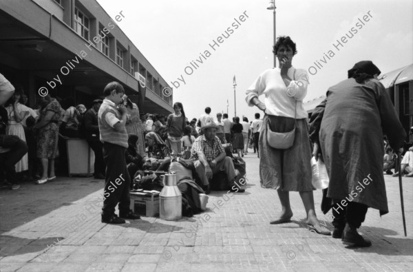 Image of sheet 19890600 photo 4: 34. Tag des Exodus türkischstämmiger 'Ausflügler', wie sie in Bulgarien genannt werden. Deportierte in der Türkei. Lastwagenschlage an der Türkisch-Bulgarischen Grenze. Auf dem Bahn-Quai von Kapikule sitzen und liegen hunderte von Türkischstämmigen BulgarInnen mit ihren Familien erschöpft in einem grossen elenden Durcheinander. Die Türkische Fahne bedeutet für viele das Symbol eines 'freien' Landes. In Bulgarien hat man sie gezwungen ihre Namen und ihre Sprache zu ändern. Oezal benützt die ca 300'000 Bulgaren für seine Wahlkampagne. Viele Kinder weinen unaufhörlich vor Erschöpfung. In Bergen von Hab und Gut entdecke ich ganze Wohnungseinrichtungen. Der Duty Free Laden ist geschlossen. Die Güterwagen, in denen die Menschen tagelang eingesperrt reisen mussten, werden nach ihrer Leerung wieder zurückfahren und noch mehr Familien in ihr Unglück stürzen. Türkei Turkey Bulgarian Refugees 1989