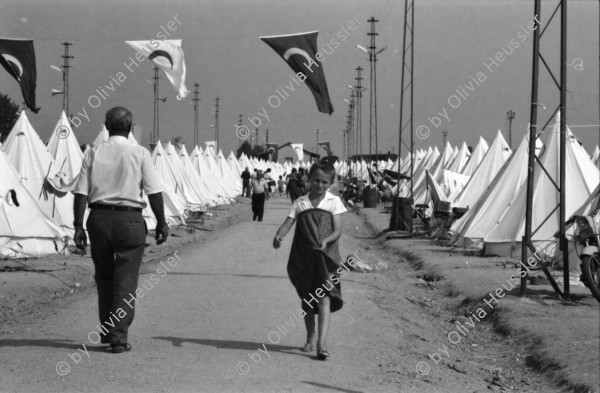 Image of sheet 19890610 photo 14: Im Vorzeigelager geordneter Heimatlosigkeit. Özal entlässt türkische Arbeiter um den Einwanderer Platz zu schaffen und noch mehr auszubeuten in den Fabriken.
Im Flüchtlingslager für die geflohenen Türkisch-stämmigen BulgarInnen und Bulgaren hat der türkische Halbmond 'Kizilay' mit der Unterstützung vom islamischen Weltkongress (Bund) 700 Zelte aufgestellt. Für 1800 Flüchtlinge. Es gibt schon eine Schule und eine Moschee. Kleine Jungen Nr. 7 werden ohne Rücksicht auf die Strapazen beschnitten. Hasan heisst der Junge auf Türkisch und Sartuslav auf bulgarisch. Die meisten dieser Menschen sind nicht lange in der Türkei geblieben. 1989
Edirne