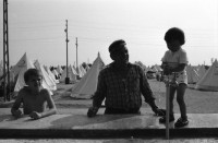Image of sheet 19890610 photo 21: Im Vorzeigelager geordneter Heimatlosigkeit. Özal entlässt türkische Arbeiter um den Einwanderer Platz zu schaffen und noch mehr auszubeuten in den Fabriken.
Im Flüchtlingslager für die geflohenen Türkisch-stämmigen BulgarInnen und Bulgaren hat der türkische Halbmond 'Kizilay' mit der Unterstützung vom islamischen Weltkongress (Bund) 700 Zelte aufgestellt. Für 1800 Flüchtlinge. Es gibt schon eine Schule und eine Moschee. Kleine Jungen Nr. 7 werden ohne Rücksicht auf die Strapazen beschnitten. Hasan heisst der Junge auf Türkisch und Sartuslav auf bulgarisch. Die meisten dieser Menschen sind nicht lange in der Türkei geblieben. 1989
Edirne