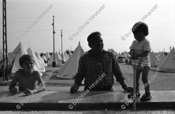 Image of sheet 19890610 photo 21: Im Vorzeigelager geordneter Heimatlosigkeit. Özal entlässt türkische Arbeiter um den Einwanderer Platz zu schaffen und noch mehr auszubeuten in den Fabriken.
Im Flüchtlingslager für die geflohenen Türkisch-stämmigen BulgarInnen und Bulgaren hat der türkische Halbmond 'Kizilay' mit der Unterstützung vom islamischen Weltkongress (Bund) 700 Zelte aufgestellt. Für 1800 Flüchtlinge. Es gibt schon eine Schule und eine Moschee. Kleine Jungen Nr. 7 werden ohne Rücksicht auf die Strapazen beschnitten. Hasan heisst der Junge auf Türkisch und Sartuslav auf bulgarisch. Die meisten dieser Menschen sind nicht lange in der Türkei geblieben. 1989
Edirne