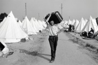 Image of sheet 19890610 photo 22: turkish Half Moon on the border with Bulgaria 
Man carries his bag on his shoulder
This turkish-original man has just arrived from central Bulgaria in this Turkish refugeecamp of the Halfmoon-Organisation. They had come to find work and residence in Turkey. A monts later most of the 300 000 returned. √ Refugee
Out of: From time to time  / VonZeitzuZeit

Exhibition
Im Bestand der Fotostiftung Schweiz 30x40 cm Baryt Vintage 1990.008 B.0226
19890620_22