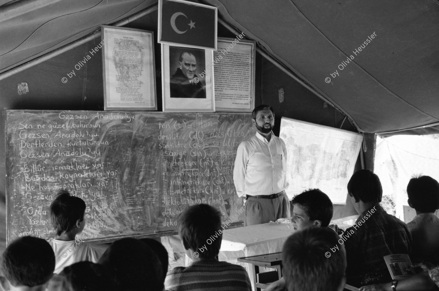 Image of sheet 19890610 photo 5: Türkischstämmige muslimische Flüchtlingskinder aus Bulgarien in der Schule für Islamische Religion im Lager des türkischen Halbmond an der Grenze zu Bulgarien. Edirne Türkei 07.89 Koranschule im Flüchtlingslager. Refugees Flüchtlinge Turkey 1989 √ This turkish-originals moslems have just arrived from central Bulgaria in this Turkish refugeecamp of the Halfmoon-Organisation. They had come to find work and residence in Turkey. A monts later most of the 300 000 returned. √ Refugee school kids boys student study tent camp 


copyright by Olivia Heussler