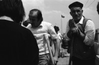 Image of sheet 19890620 photo 1: Auf dem Bahnsteig von Kapikule entdecke ich immer wieder zwischen Sack und Pack vereinsamte Menschen im Elend. Hab und Gut. Einwanderungsbüro. Türkische Fahne. Eine Hand zeigt auf den leeren Güterwagen, wo nicht nur Hausrat transportiert wird, sondern Menschen über 10 Stunden ohne Frischluft und Wasser reisen. Türkei Kapikule 1989