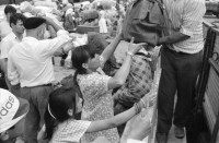 Image of sheet 19890620 photo 16: Auf dem Bahnsteig von Kapikule entdecke ich immer wieder zwischen Sack und Pack vereinsamte Menschen im Elend. Hab und Gut. Einwanderungsbüro. Türkische Fahne. Eine Hand zeigt auf den leeren Güterwagen, wo nicht nur Hausrat transportiert wird, sondern Menschen über 10 Stunden ohne Frischluft und Wasser reisen. Türkei Kapikule 1989