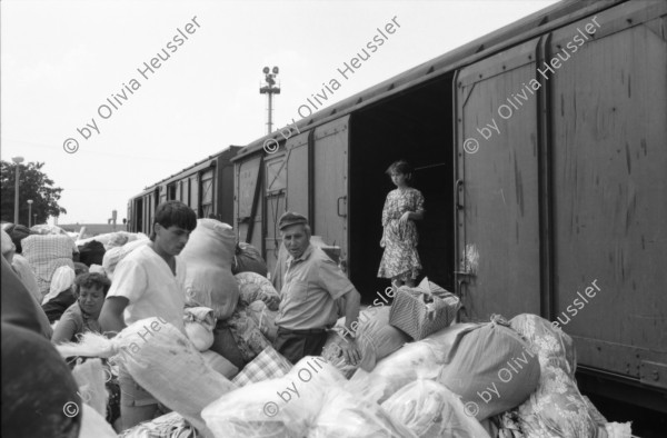 Image of sheet 19890620 photo 19: Auf dem Bahnsteig von Kapikule entdecke ich immer wieder zwischen Sack und Pack vereinsamte Menschen im Elend. Hab und Gut. Einwanderungsbüro. Türkische Fahne. Eine Hand zeigt auf den leeren Güterwagen, wo nicht nur Hausrat transportiert wird, sondern Menschen über 10 Stunden ohne Frischluft und Wasser reisen. Türkei Kapikule 1989