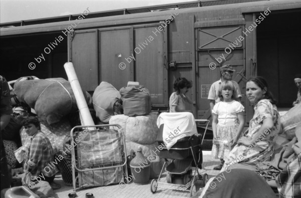 Image of sheet 19890620 photo 4: Auf dem Bahnsteig von Kapikule entdecke ich immer wieder zwischen Sack und Pack vereinsamte Menschen im Elend. Hab und Gut. Einwanderungsbüro. Türkische Fahne. Eine Hand zeigt auf den leeren Güterwagen, wo nicht nur Hausrat transportiert wird, sondern Menschen über 10 Stunden ohne Frischluft und Wasser reisen. Türkei Kapikule 1989