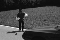 Image of sheet 19890700 photo 10: 20 Kurden gehen in einem Protestmarsch von Zürich nach Bern zu Fuss. Protest gegen die Ausschaffungspolitik der Schweizer Regierungen. Die ländliche Bevölkerung hat kein Interesse an der Informationen der Kurden. Sie warten auf ein Radfahrer Velorennen rennen. In einer Badeanstalt. Dicker fetter Mann mit glanz auf der Brust in Badehose im Schwimmbad. Bäbe Weber und Pierre Mennel tanzen auf dem 'Felde'.
