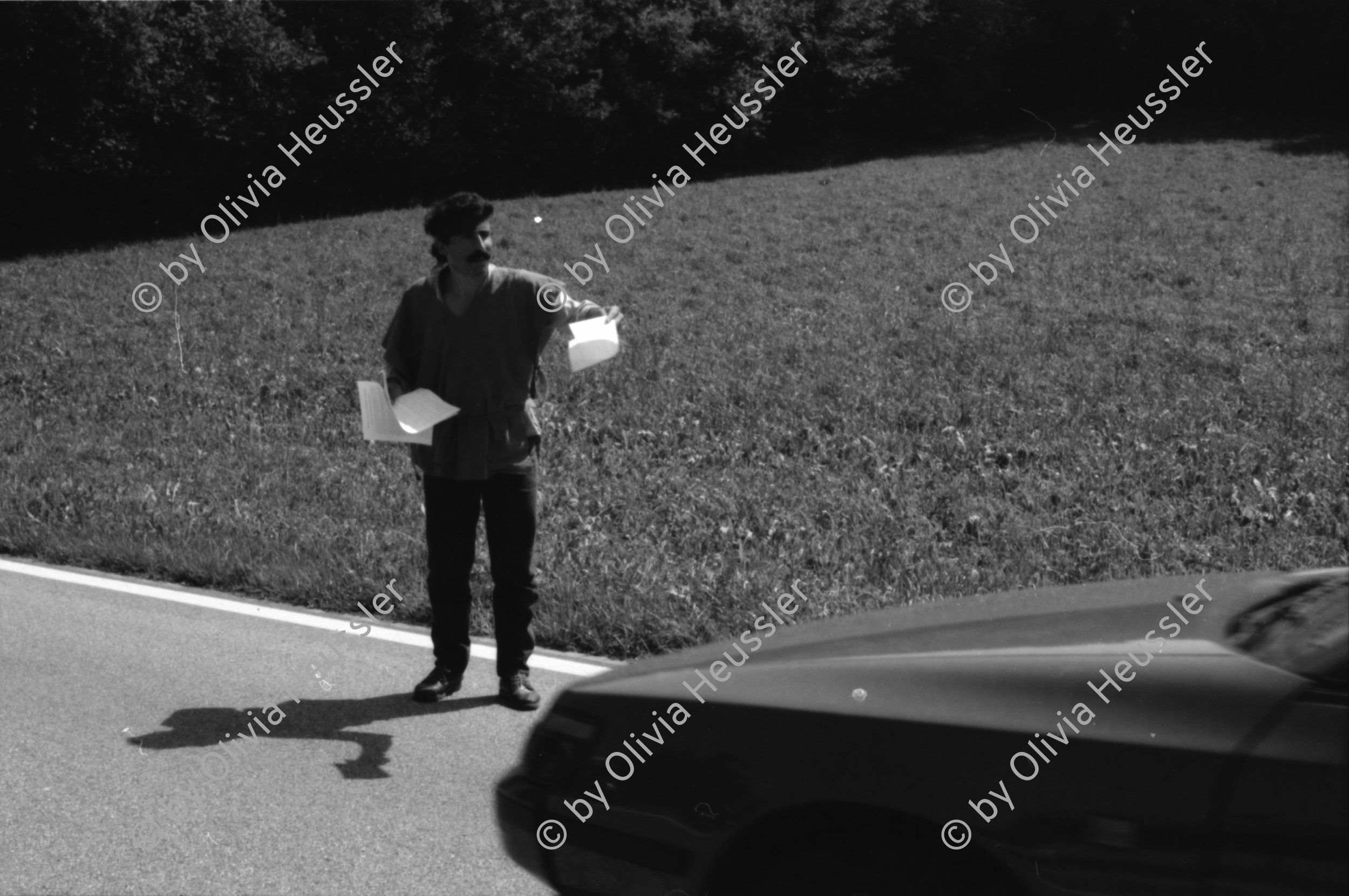 Image of sheet 19890700 photo 10: 20 Kurden gehen in einem Protestmarsch von Zürich nach Bern zu Fuss. Protest gegen die Ausschaffungspolitik der Schweizer Regierungen. Die ländliche Bevölkerung hat kein Interesse an der Informationen der Kurden. Sie warten auf ein Radfahrer Velorennen rennen. In einer Badeanstalt. Dicker fetter Mann mit glanz auf der Brust in Badehose im Schwimmbad. Bäbe Weber und Pierre Mennel tanzen auf dem 'Felde'.