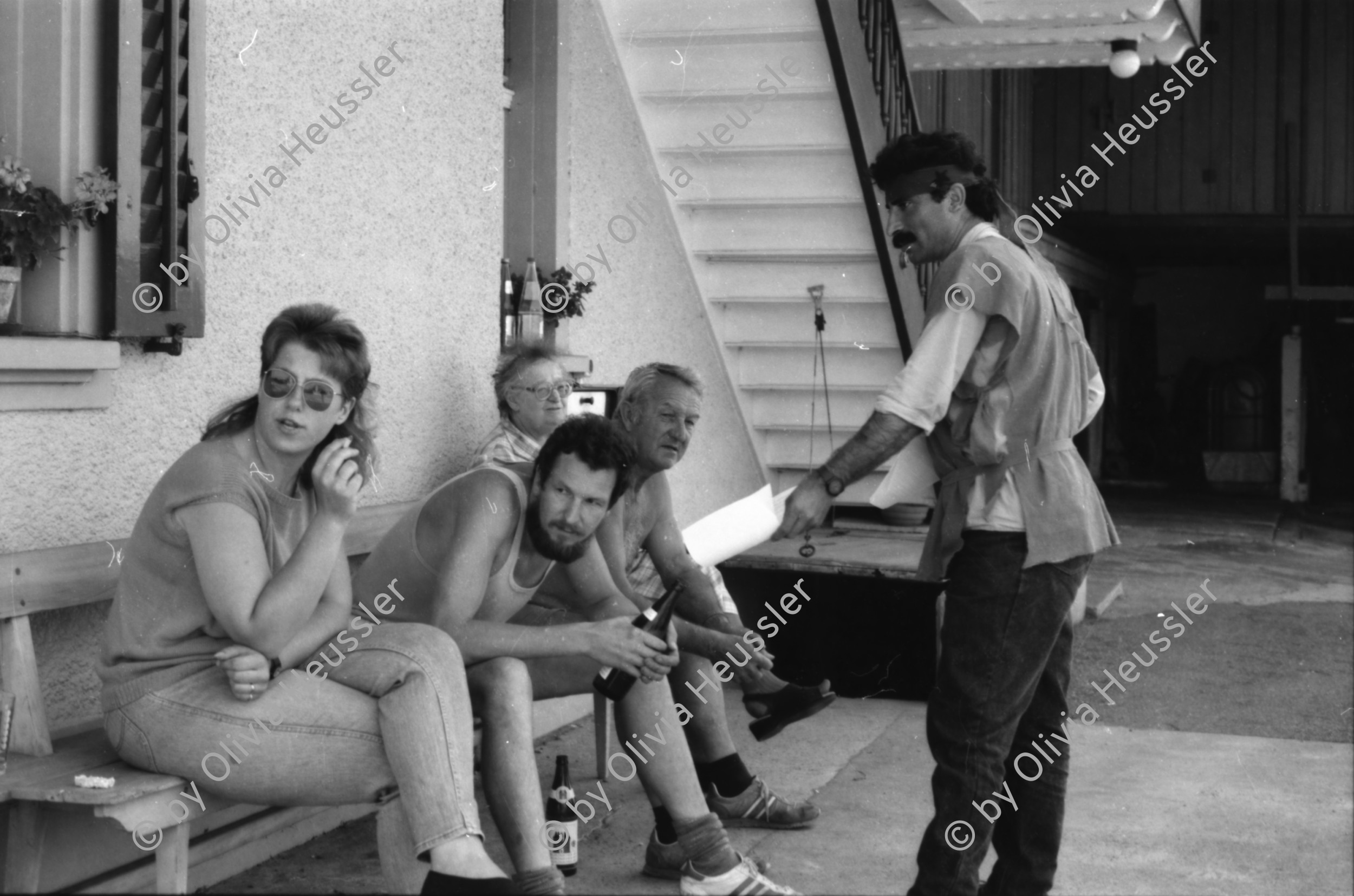 Image of sheet 19890700 photo 15: 20 Kurden gehen in einem Protestmarsch von Zürich nach Bern zu Fuss. Protest gegen die Ausschaffungspolitik der Schweizer Regierungen. Die ländliche Bevölkerung hat kein Interesse an der Informationen der Kurden. Sie warten auf ein Radfahrer Velorennen rennen. In einer Badeanstalt. Dicker fetter Mann mit glanz auf der Brust in Badehose im Schwimmbad. Bäbe Weber und Pierre Mennel tanzen auf dem 'Felde'.