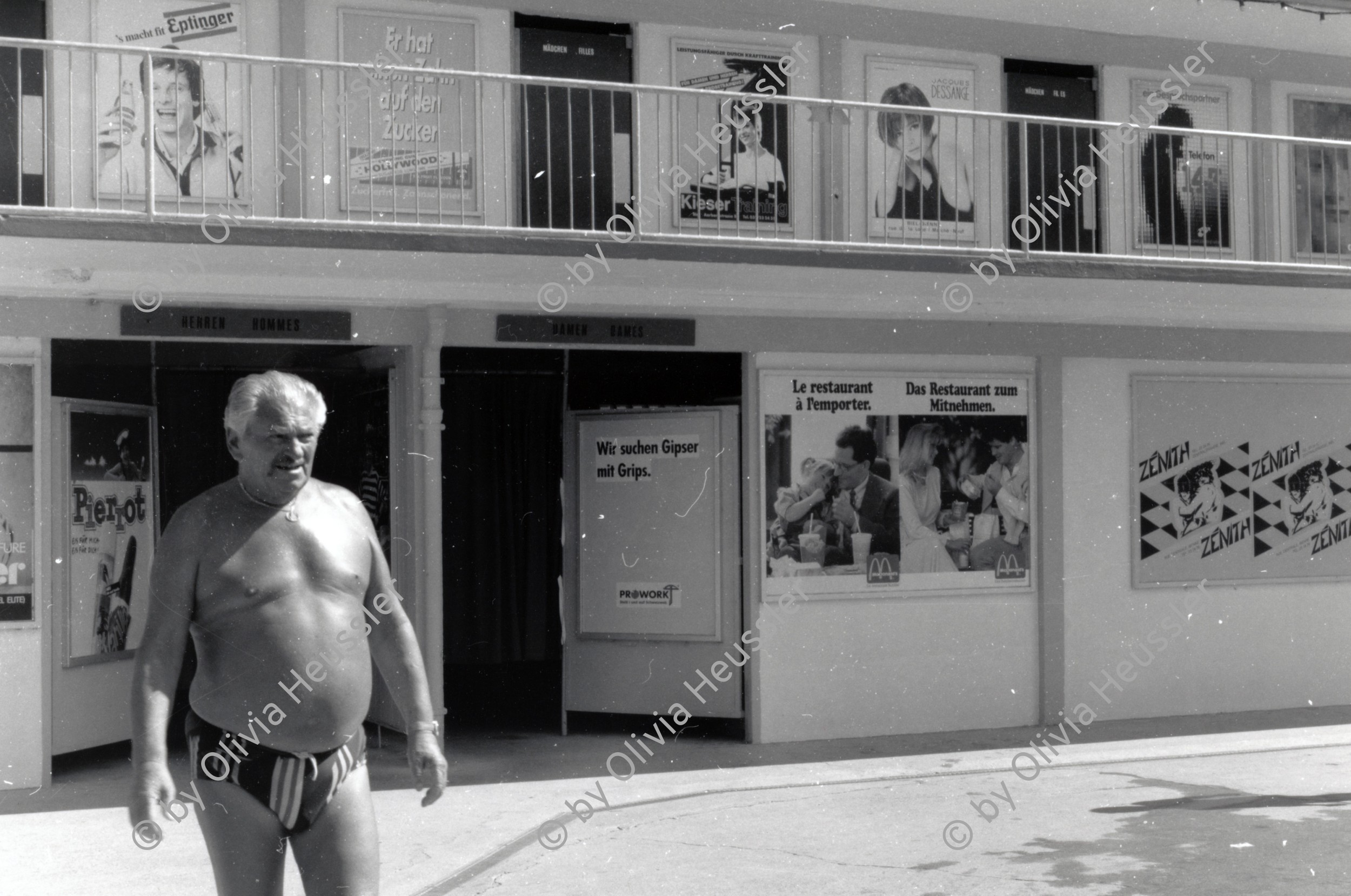 Image of sheet 19890700 photo 27: Mann in Badehose vor Plakatwerbung im Schwimmbad, 1989.