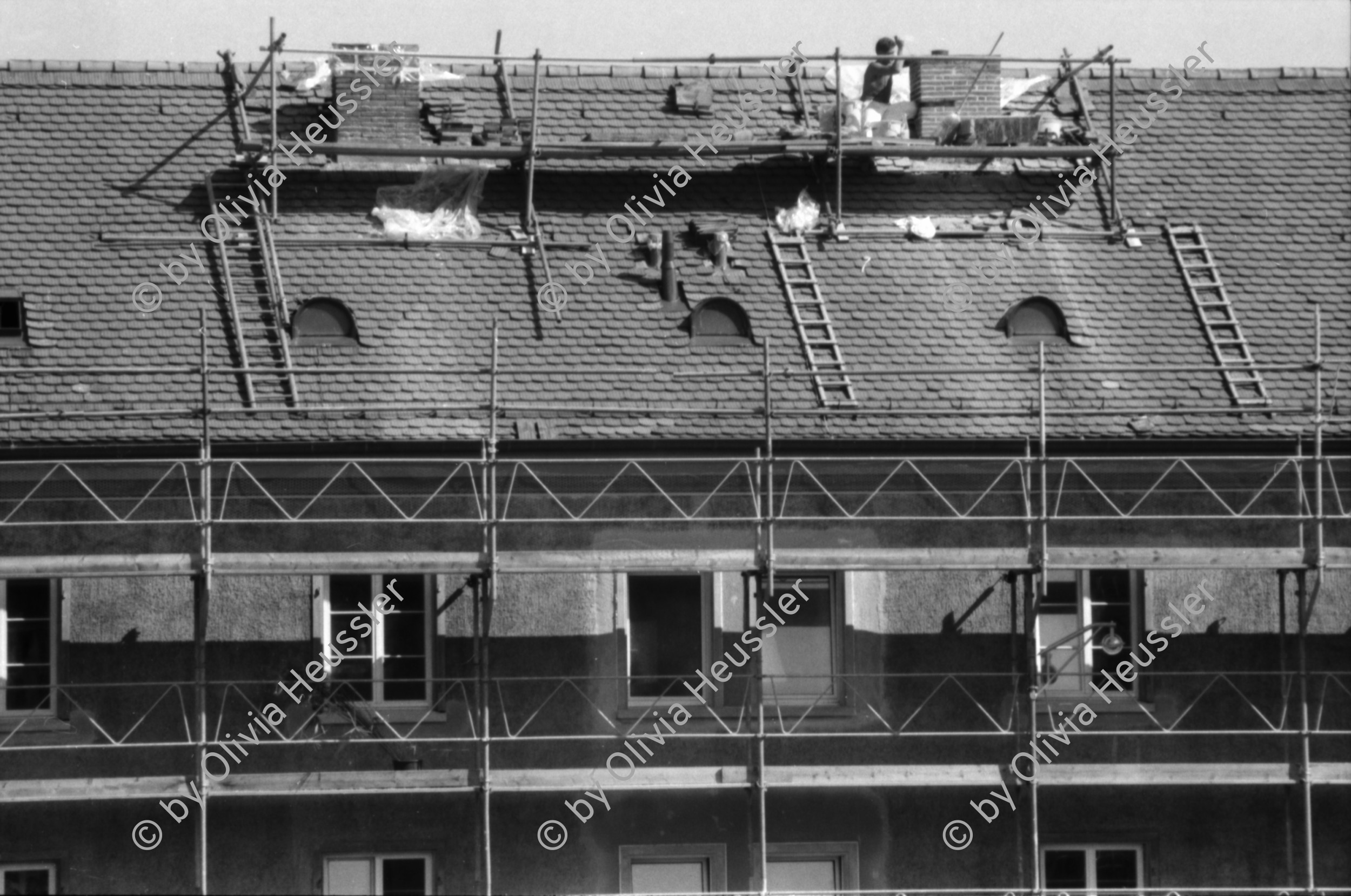 Image of sheet 19890780 photo 8: Erismannhof im Gerüst während des Umbaus. Arbeiter auf dem Dach. Platzspitz. Drogen Protest gegen Razzien. Britische-Holz-Telefonkabine als Kleiderschrank auf Gehsteig mit Frau. Mehr Nischen und Platz ohne Hatz. Mädchen nehmen Unterricht in Selbstverteidigung Wendo. Im GZ Bachwiesen mit Oruscha. Zürich