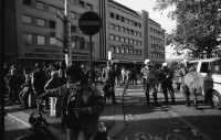Image of sheet 19890820 photo 11: Thomas Kern liegend. Catherine Boss spricht an Antifa Demo. Raffi mit Faschos nein Danke auf Wange gemalt. Gegen Rassismus. Beamte Polizei Grenadiere. Schönes Licht in der Langstrasse. Polizei schützt Demonstration Protest von Angriffen einer Gruppe Skin Heads. Zürich Aussersihl Kreis 4 1989