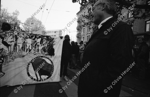 Image of sheet 19890820 photo 12: Thomas Kern liegend. Catherine Boss spricht an Antifa Demo. Raffi mit Faschos nein Danke auf Wange gemalt. Gegen Rassismus. Beamte Polizei Grenadiere. Schönes Licht in der Langstrasse. Polizei schützt Demonstration Protest von Angriffen einer Gruppe Skin Heads. Zürich Aussersihl Kreis 4 1989