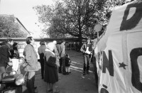 Image of sheet 19890820 photo 13: Thomas Kern liegend. Catherine Boss spricht an Antifa Demo. Raffi mit Faschos nein Danke auf Wange gemalt. Gegen Rassismus. Beamte Polizei Grenadiere. Schönes Licht in der Langstrasse. Polizei schützt Demonstration Protest von Angriffen einer Gruppe Skin Heads. Zürich Aussersihl Kreis 4 1989