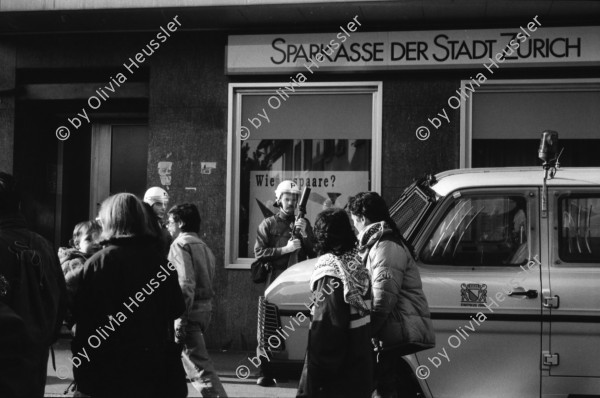 Image of sheet 19890820 photo 19: Thomas Kern liegend. Catherine Boss spricht an Antifa Demo. Raffi mit Faschos nein Danke auf Wange gemalt. Gegen Rassismus. Beamte Polizei Grenadiere. Schönes Licht in der Langstrasse. Polizei schützt Demonstration Protest von Angriffen einer Gruppe Skin Heads. Zürich Aussersihl Kreis 4 1989