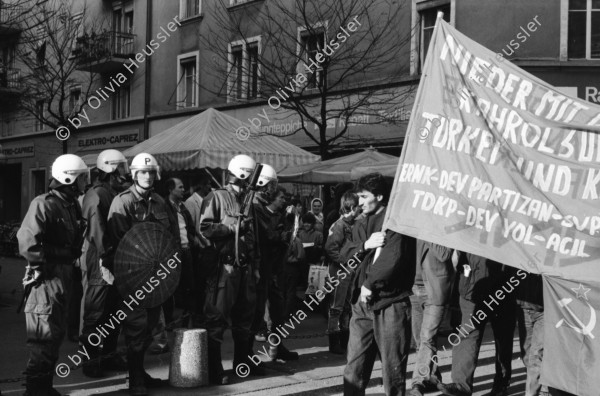 Image of sheet 19890820 photo 22: Thomas Kern liegend. Catherine Boss spricht an Antifa Demo. Raffi mit Faschos nein Danke auf Wange gemalt. Gegen Rassismus. Beamte Polizei Grenadiere. Schönes Licht in der Langstrasse. Polizei schützt Demonstration Protest von Angriffen einer Gruppe Skin Heads. Zürich Aussersihl Kreis 4 1989