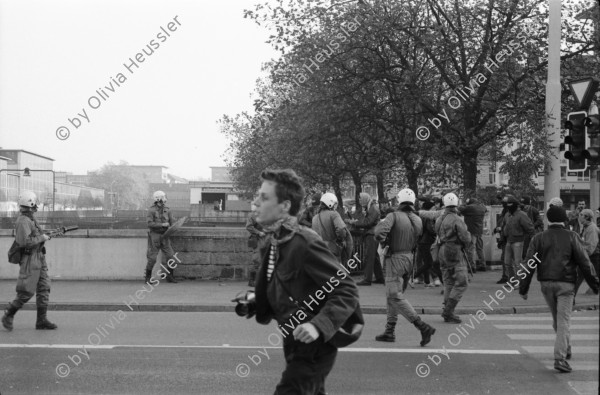 Image of sheet 19890820 photo 28: Thomas Kern liegend. Catherine Boss spricht an Antifa Demo. Raffi mit Faschos nein Danke auf Wange gemalt. Gegen Rassismus. Beamte Polizei Grenadiere. Schönes Licht in der Langstrasse. Polizei schützt Demonstration Protest von Angriffen einer Gruppe Skin Heads. Zürich Aussersihl Kreis 4 1989