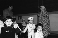 Image of sheet 19890860 photo 28: Demonstration im Kasernen Innenhof. Modepuppe sitzt an Nähmaschine im Freien. In einem Lebensmittelladen für TürkInnen. Asyl bewerber Innen. Uniformen hängen da, während Männer essen. Zwei Frauen stehen da. Unbekannte Gestalt beim Telefonieren in Telefon Kabine. Schliessung eines Ladens. Zwei Männer als Türkisches Beschneidung fest in einer Turnhalle in Pratteln. Frauen und Kinder und Männer tanzen zusmmen . Basel Brauchtum turkish boy circumcision child tradition muslim religion asylum seekers human rights Switzerland Schweiz 1989