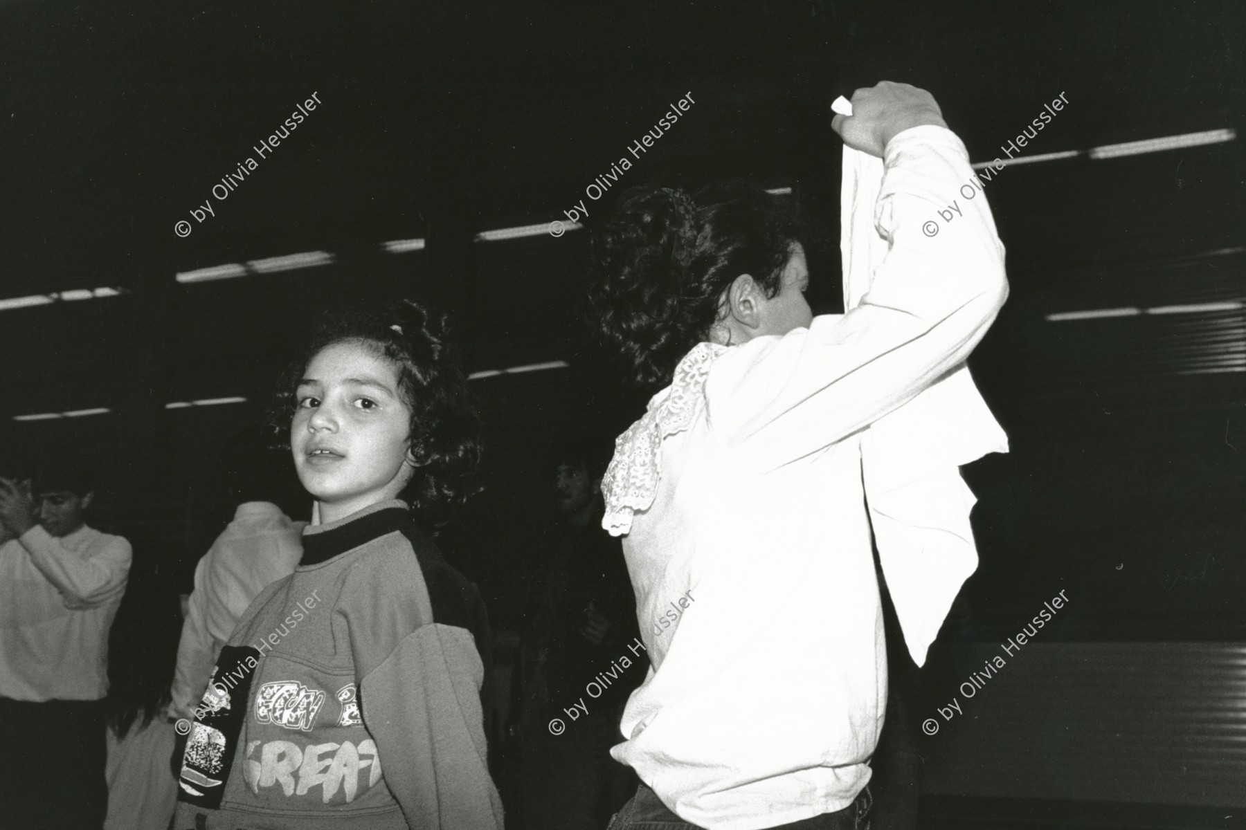 Image of sheet 19890870 photo 17: Türkisches Beschneidungs fest in einer Turnhalle in Pratteln. Frauen und Männer und Kinder tanzen. Ein Mädchen führt die Gruppe mit einem weissen Taschentuch an. Kanton Baselland 1989 √ Pratteln 
Religion Kultur Tradition Imigranten Emigranten