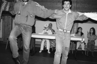 Image of sheet 19890870 photo 7: frtsg. 890860 Türkisches Beschneidungs ritual fest in einer Turnhalle in Pratteln. Frauen und Männer und Kinder tanzen. Ein Mädchen führt die Gruppe mit einem weissen Taschentuch. Zwei alte Männer sitzen neben dem kleinen Jungen in Uniform. Bild mit seiner Familie. Priska Fetz von Aarau tanzt auch mit. Familiengruppenbild. Kanton Baselland 1989  Schweiz Turkey Türkei Refugees Flüchtlinge Boy circumcision