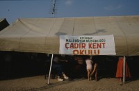 Image of sheet 19893005 photo 23: Vertriebene Türkischstämmige aus Bulgarien, Edirne 1989.

Mädchen vor Zelt im Flüchtlingslager