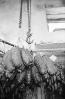 Image of sheet 19900010 photo 21: Würste hängen in grossen Massen auch Hirsch und Wild würste. Das Fleisch Bündnerfleisch wird an der Luft getrocknet und hängt draussen unter dem Dach.