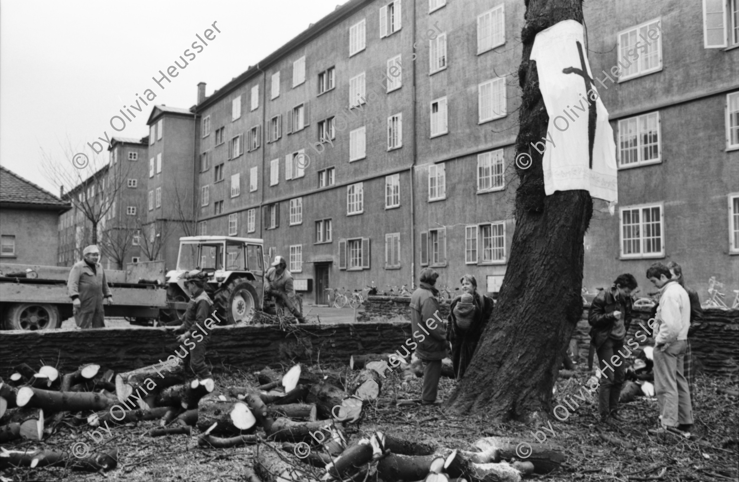 Image of sheet 19900040 photo 14: Bewohnerinnen protestieren gegen die Fällung einer 70ig jährigen Kastanie, städtische Wohnsiedlung Erismannhof, Zürich 1990.

Ein Leintuch mit einem aufgemalten Kreuz hängt am Baum. Protest Zürich 1990 √ wood tree protest 
In urban housing development Erismannhof an old chestnut will be cut
Switzerland Swiss kreis vier Aussersihl Europe