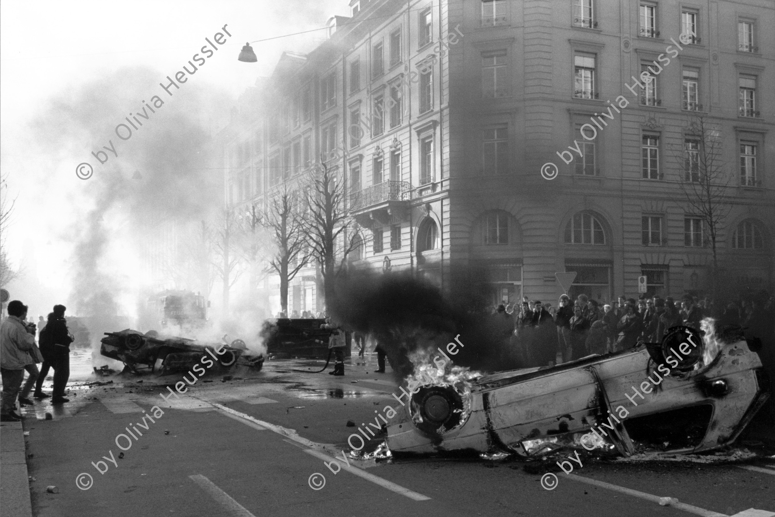 Image of sheet 19900150 photo 19: Während der 'Fichendemo' in Bern wurden vor dem 
Brennenden Auto vor dem Bundeshaus an der Anti Schnüfflerdemo. Bern 1990 √ Schweiz Switzerland Europe Protest Auto geht in Flammen und Rauch auf.
A masked protester in front of a burning car in front of the Parliament Building of the Bundeshaus.

Der sogenannte Fichenskandal (auch Fichenaffäre) ist ein Skandal der neueren Schweizer Geschichte in der Endphase des Kalten Krieges. Fiche [ˈfiʃə] ist die französische Bezeichnung für Karteikarte. Davon abgeleitet hat sich in der Schweiz das Wort «Fichenstaat» als Umschreibung für einen «Schnüffelstaat» gebildet

The Fichenaffäre or Secret Files Scandal shook public opinion in Switzerland in 1989. That year, it was revealed that the Swiss federal authorities, as well as the cantonal police forces, had put in place a system of mass surveillance of the population