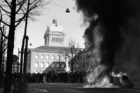 Image of sheet 19900150 photo 6: A masked protester in front of a burning car in front of the Parliament Building of the Bundeshaus.

Der sogenannte Fichenskandal (auch Fichenaffäre) ist ein Skandal der neueren Schweizer Geschichte in der Endphase des Kalten Krieges. Fiche [ˈfiʃə] ist die französische Bezeichnung für Karteikarte. Davon abgeleitet hat sich in der Schweiz das Wort «Fichenstaat» als Umschreibung für einen «Schnüffelstaat» gebildet

The Fichenaffäre or Secret Files Scandal shook public opinion in Switzerland in 1989. That year, it was revealed that the Swiss federal authorities, as well as the cantonal police forces, had put in place a system of mass surveillance of the population