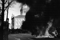 Image of sheet 19900150 photo 8: Während der 'Fichendemo' in Bern wurden vor dem Bundeshaus Autos verbrannt, Bern 1990.


Europe Protest 
A masked protester in front of a burning car in front of the Parliament Building of the Bundeshaus.


The Fichenaffäre or Secret Files Scandal shook public opinion in Switzerland in 1989. That year, it was revealed that the Swiss federal authorities, as well as the cantonal police forces, had put in place a system of mass surveillance of the population