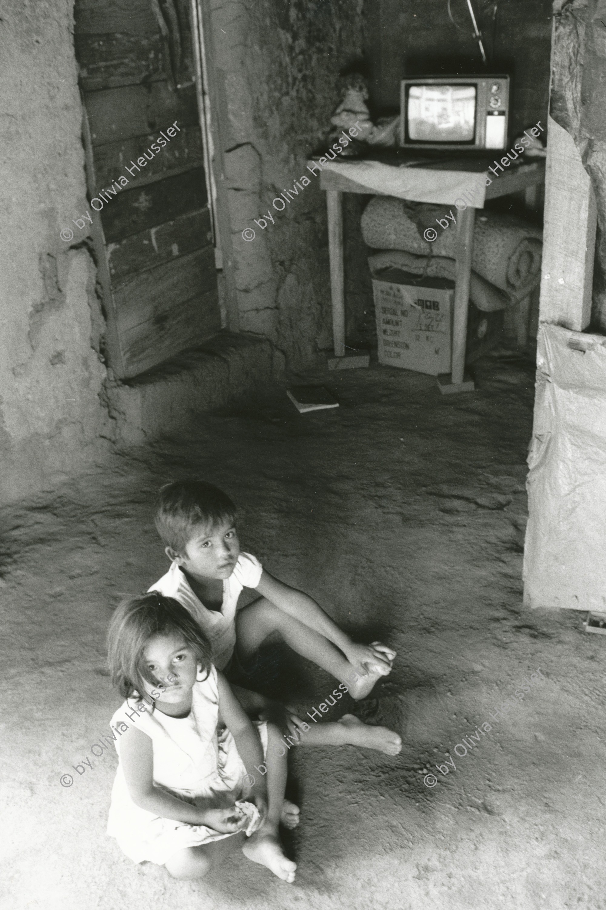 Image of sheet 19900250 photo 19900250: Zwei Kinder sitzen vor einem TV Gerät Television media auf dem Erd Boden. Erde Nicaragua. 1990 √ children salon sitting on the earth America central child boy and girl Mädchen und Knabe