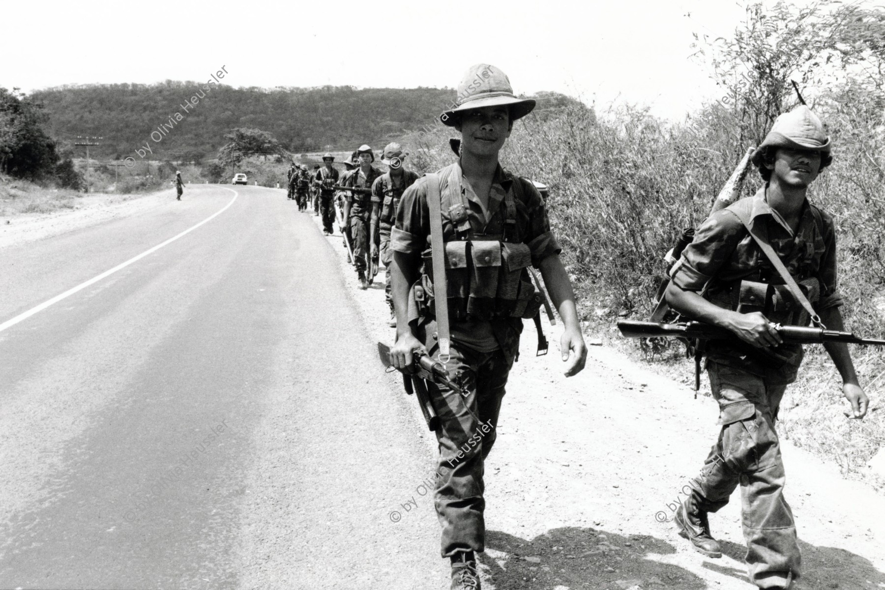 Image of sheet 19900290 photo 13: Mit AK-47 Sturmgewehr bewaffnete Sandinistische Soldaten EPS marschieren auf der Panamericana. Nicaragua 1990

Frente Sandinista de Liberación Nacional FSLN
Ejército Popular Sandinista EPS

AK-47 ist die Abkürzung für Awtomat Kalaschnikowa, obrasza 47 (kyrillisch Автомат Калашникова образца 47), ein sowjetisch-russisches Sturmgewehr. Es ist die am meisten produzierte Handfeuerwaffe weltweit. Schätzungen gehen von 80[1] bis 100[2] Millionen produzierten Exemplaren aus. Etwa 60

Military Army Armee Militär Soldier Soldat Batallon Batalion