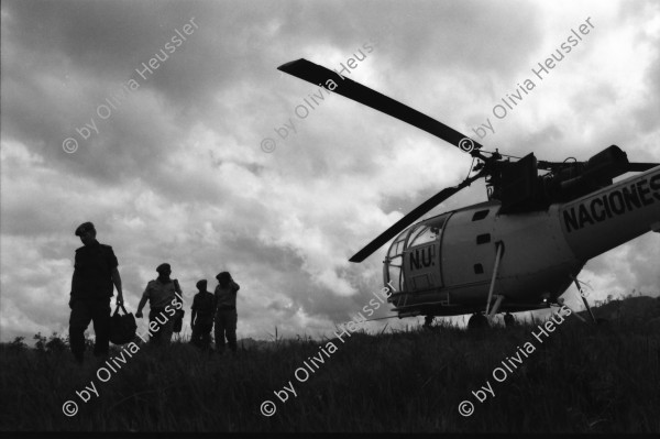 Image of sheet 19900310 photo 2: UN-Helikopter landet unter Aufsicht eines UN Soldaten auf kleinem Hügel in Yamales. Alte ausgediente unbrauchbare Waffen liegen zum symbolischen Zerstörungsakt der UN Truppen auf einer Plane bereit. Junge posiert dazwischen. Portrait Nr. 8 Beretta und Nr. 7 Uzi Italienische und israelische Klein maschinen gewehre. Staub. 12 General Quesada. 13 und 14 Cmdte. Siro Somozist. UN-Soldaten brennen die Waffen nieder. Kriegs Zerstörung mit Flammenwerfer. UN Soldaten sind mit Deutschen Heckler und Koch bewaffnet. Honduras Yamales 1990 rifle weapon arms