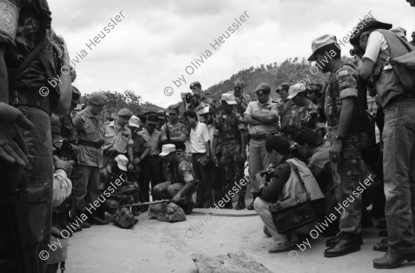 Image of sheet 19900310 photo 22: UN-Helikopter landet unter Aufsicht eines UN Soldaten auf kleinem Hügel in Yamales. Alte ausgediente unbrauchbare Waffen liegen zum symbolischen Zerstörungsakt der UN Truppen auf einer Plane bereit. Junge posiert dazwischen. Portrait Nr. 8 Beretta und Nr. 7 Uzi Italienische und israelische Klein maschinen gewehre. Staub. 12 General Quesada. 13 und 14 Cmdte. Siro Somozist. UN-Soldaten brennen die Waffen nieder. Kriegs Zerstörung mit Flammenwerfer. UN Soldaten sind mit Deutschen Heckler und Koch bewaffnet. Honduras Yamales 1990 rifle weapon arms