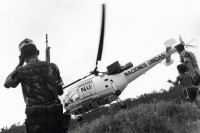 Image of sheet 19900310 photo 4: Angehörige der UNO-Friedenstruppen aus Venezuela und ein Junge Kind und beobachten die Landung eines UN - Helikopters im Contra Contrarebellen Camp Yamales Die Contra wird dort von der Uno entwaffnet. Honduras 1990 √
Naciones Unidas boy child war helicopter