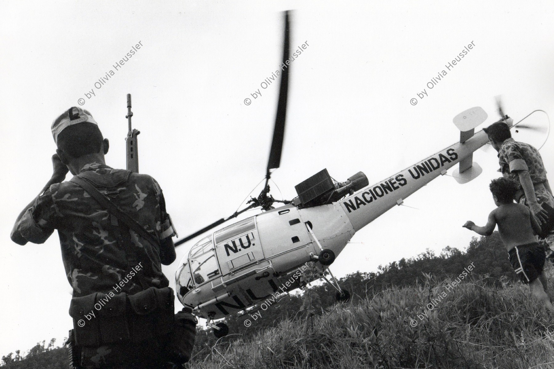 Image of sheet 19900310 photo 4: Angehörige der UNO-Friedenstruppen aus Venezuela und ein Junge Kind und beobachten die Landung eines UN - Helikopters im Contra Contrarebellen Camp Yamales Die Contra wird dort von der Uno entwaffnet. Honduras 1990 √
Naciones Unidas boy child war helicopter