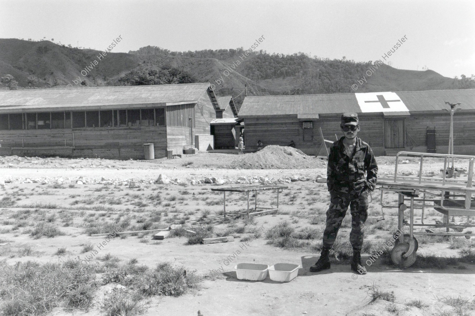 Image of sheet 19900320 photo 25: Im Contra Spital El Aureliano von ONUCA und UNHCR CIAV betreut. Soldat Contrarebell steht vor Militär Spital Barake. ACNUR betreut Contras. Portrait. Honduras Yamales 1990 √

Military Army Armee Militär Soldier Soldat 
ONUCA and ONUSAL were two United Nations peacekeeping missions deployed in Central America during the late 1980s and early 1990s.