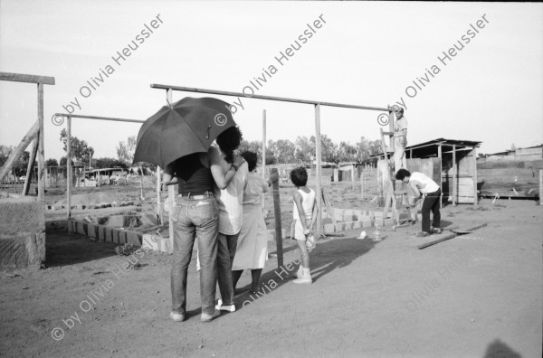 Image of sheet 19900380 photo 26: Nach einem Dekret der Sandinisten konnten viele bis zum 25.4 ihre Häuser rund um Managua aufstellen. 1. Mai Demonstration Protest in Esteli. Zwei Pferde unter Strohdach. Mutter wäscht draussen Kinder stehen daneben. Bretterbuden. Frau putzt ihre Zähne.Mann zügelt seine Möbel mit Fahrrad Velo. Stravato Mike AP Photograph 28 Donaldo. Stühle im Hotel. Que se respeten los Acuerdos. Demo. Esteli Nicaragua 1990