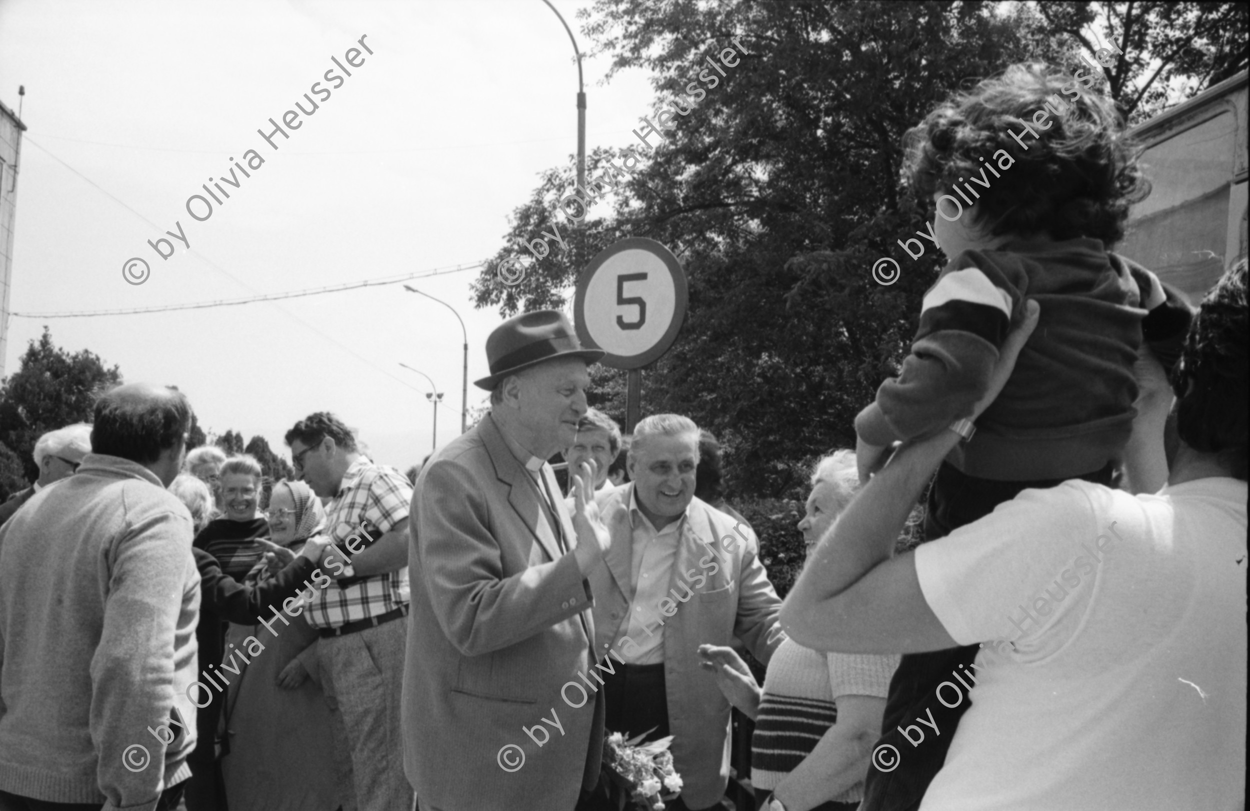 Image of sheet 19900410 photo 33: Kinder spielen mit 'Gondel' in Wohnsiedlung. Soldaten, Mütter und Väter etc.  legen auf einem neuen Friedhof für ihre gefallenen Freunde u/o Brüder und Söhne Blumen nieder. Wachsresten. Flugzeug Propeller Flügel. Portrait Susan und Judith (ihre Tochter) Hotel in Sibiu gebaut von Sohn Cheaucescu's. Edel Restaurant. Kind malt auf Strasse mit Kreide. Vater und Kind (im selbstgebastelten Kinderwagen). Markt. Rumania Romania 1990