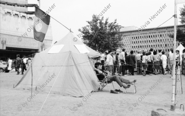 Image of sheet 19900420 photo 18: Bei Theodor Redlov seinem Sohn mit Susan. Theodor mit Bild von Fotos seiner Familie. Auf Handführung der Rolltreppe liegt einer. Mit Emilia Anna Clopath unterwegs. Golani demonstrieren auf Universitätsplatz. Besetzung mit Zelten. Mädchen schreibt Pank auf ihre Jeans. Roma verkauft Flüssiges. Tätowierter Arm.
Soldaten und junge Frau mit Blume vor Panzer. Hotel Bucuresti. Anna Emilia Clopath (gest.) (Schwester von Donata Bäuerin in Donat) und Olivia und Roland Bigler CICR im grossen Badezimmer des ehemaligen rumänischen Aussenministers. Dusche. 
Golani demonstrate on University Square. Occupation with tents political protest
Bukarest Romania Rumänien 1990