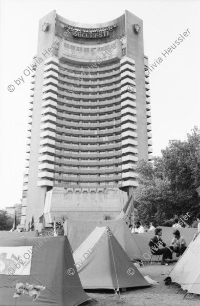 Image of sheet 19900420 photo 30: Bei Theodor Redlov seinem Sohn mit Susan. Theodor mit Bild von Fotos seiner Familie. Auf Handführung der Rolltreppe liegt einer. Mit Emilia Anna Clopath unterwegs. Golani demonstrieren auf Universitätsplatz. Besetzung mit Zelten. Mädchen schreibt Pank auf ihre Jeans. Roma verkauft Flüssiges. Tätowierter Arm.
Soldaten und junge Frau mit Blume vor Panzer. Hotel Bucuresti. Anna Emilia Clopath (gest.) (Schwester von Donata Bäuerin in Donat) und Olivia und Roland Bigler CICR im grossen Badezimmer des ehemaligen rumänischen Aussenministers. Dusche. 
Golani demonstrate on University Square. Occupation with tents political protest
Bukarest Romania Rumänien 1990