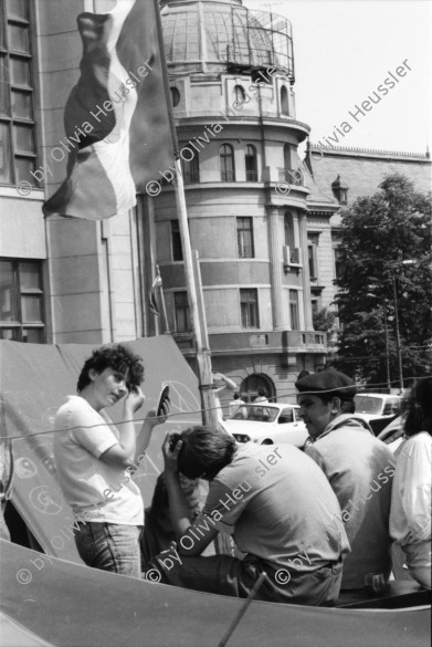 Image of sheet 19900440 photo 12: Supermarkt, Judentum jüdisch geschlossene Synagoge, Jos Comunism=Kein Komunismus. Religiöse Golanis auf dem Universitätsplatz protestieren gegen die Regierung von Ion Iliescu vom FSN 
Golani=Vagabunden Illiescu hat sie so genannt. Zeltlager der Golani auf dem Universitäts Platz. Frau schläft neben Zelt. Bukarest Rumänien, Romania, Rumania, 1990 

Psychiatrische Klinik in Zärnesti. Frauen Portrait. Frauen liegen im Bett, eine liest. Die 23 jährige Blanca Mihai sagt: 'Ich bin eine Roma. Der Name kommt aus dem Sanskrit und heisst: Eine Person, die zu unserer Gruppe gehört. Ich habe drei Jahre als Strassenputzerin für die Stadt gearbeitet. Eine Angehörige meiner Kollegin hat mir die Arbeit weggenommen. Jetzt bin ich krank und lebe hier unter alten Menschen'.

The National Salvation Front (Romanian: Frontul Salvării Naţionale, FSN) was the governing body of Romania in the first weeks after the Romanian Revolution of 1989, subsequently turned into a political party. FSN is the common root of two of the three largest political parties in Romania today: the Social Democratic Party (PSD) and the Democratic Liberal Party (PD-L).