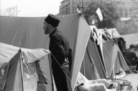 Image of sheet 19900440 photo 13: Supermarkt, Judentum jüdisch geschlossene Synagoge, Jos Comunism=Kein Komunismus. Religiöse Golanis auf dem Universitätsplatz protestieren gegen die Regierung von Ion Iliescu vom FSN 
Golani=Vagabunden Illiescu hat sie so genannt. Zeltlager der Golani auf dem Universitäts Platz. Frau schläft neben Zelt. Bukarest Rumänien, Romania, Rumania, 1990 

Psychiatrische Klinik in Zärnesti. Frauen Portrait. Frauen liegen im Bett, eine liest. Die 23 jährige Blanca Mihai sagt: 'Ich bin eine Roma. Der Name kommt aus dem Sanskrit und heisst: Eine Person, die zu unserer Gruppe gehört. Ich habe drei Jahre als Strassenputzerin für die Stadt gearbeitet. Eine Angehörige meiner Kollegin hat mir die Arbeit weggenommen. Jetzt bin ich krank und lebe hier unter alten Menschen'.

The National Salvation Front (Romanian: Frontul Salvării Naţionale, FSN) was the governing body of Romania in the first weeks after the Romanian Revolution of 1989, subsequently turned into a political party. FSN is the common root of two of the three largest political parties in Romania today: the Social Democratic Party (PSD) and the Democratic Liberal Party (PD-L).