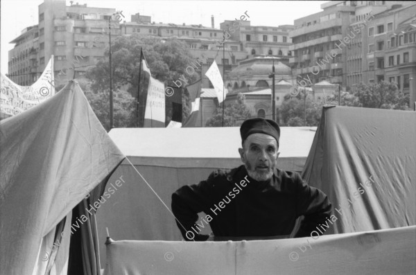 Image of sheet 19900440 photo 15: Supermarkt, Judentum jüdisch geschlossene Synagoge, Jos Comunism=Kein Komunismus. Religiöse Golanis auf dem Universitätsplatz protestieren gegen die Regierung von Ion Iliescu vom FSN 
Golani=Vagabunden Illiescu hat sie so genannt. Zeltlager der Golani auf dem Universitäts Platz. Frau schläft neben Zelt. Bukarest Rumänien, Romania, Rumania, 1990 

Psychiatrische Klinik in Zärnesti. Frauen Portrait. Frauen liegen im Bett, eine liest. Die 23 jährige Blanca Mihai sagt: 'Ich bin eine Roma. Der Name kommt aus dem Sanskrit und heisst: Eine Person, die zu unserer Gruppe gehört. Ich habe drei Jahre als Strassenputzerin für die Stadt gearbeitet. Eine Angehörige meiner Kollegin hat mir die Arbeit weggenommen. Jetzt bin ich krank und lebe hier unter alten Menschen'.

The National Salvation Front (Romanian: Frontul Salvării Naţionale, FSN) was the governing body of Romania in the first weeks after the Romanian Revolution of 1989, subsequently turned into a political party. FSN is the common root of two of the three largest political parties in Romania today: the Social Democratic Party (PSD) and the Democratic Liberal Party (PD-L).