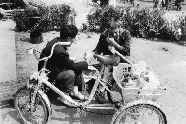 Image of sheet 19900440 photo 18: Zwei Arbeiter mit ihrem Dreirad Fahrrad Velo beim Mittagessen in der Stadt. Bukarest. Rumänien 05.90 Rumania Romania 1990 √