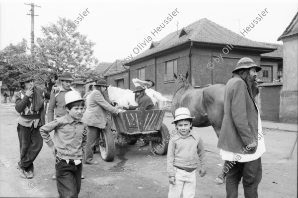 Image of sheet 19900480 photo 13: frtsg. 900470 In Copsa Mica treffe ich einen Roma Stamm, Jambasi, an. Sie sind fahrende Viehhändler und ungarisch stämmige. Jambasi Männer mit langen Bärten und Kleider wie vor damals ca. 80 Jahren. Frauen tragen Säuglinge. Kinder stehen da. Im Pferdewagen trinkt einer Wein und isst Käse. (Der Spiegel) Ich schenke der Frau ein grosses Stück Käse das ich von einem Käsebauern vorher geschenkt gekriegt habe. Die Frau ist entäuscht, da aus dem westlichen
 Plastiksack ABM keine westlichen Produkte kamen. Der Plastiksack
 kriegt mehr Wert als der Käse. Zwei alte Frauen vor Supermarkt. Zwei Arbeiter
 mit Kind im Kinderwagen. Frau im Hintergrund Kamine die Russ
 verschleudern, alles ist schwarz. Im und vor  Wahllokal in Sibiu. Mann liest Zeitung mit Hut. Kind dazwischen. Copsa Mica Rumänien Romania Rumania    1990  
The Roma (Roma in Romani; Romi or Țigani in Romanian) constitute one of the largest minorities in Romania. According to the 2011 census, they number 619,007 people or 3.2% of the total population, being the second-largest ethnic minority in Romania after Hungarians. The Roma are Romania's most socially and economically disadvantaged minority, with high illiteracy levels