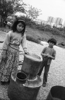 Image of sheet 19900500 photo 33: In den Strassen von Sibiu arbeiten die Romni Romi Roma als Goldschmiede und Händler mit Silberwaren. Junge mit seinem Vater. Zug und Soldat. Ueli Kern und Anna Emilia Clopath bei der Familie Mihai in Sibiu. Adina Popa übersetzt uns. Grossmutter Mihai spricht noch russisch die kleine Blanca lässt ihre Urgrossmutter nicht aus den Augen. Die Romni wurden um 1945 ? in der Sowietunion nach Moldawien zwangsinterniert. Die Familie Mihai arbeitet auch im Kesselflicken. Rumänien Romania 1990