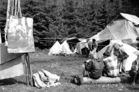 Image of sheet 19900540 photo 10: Das Camp der WaffenplatzgegnerInnen steht kurz vor der polizeilichen Räumung. Waffenplatzgegner Camp Endart Plakat Police Polizisten küssen sich. Kiss Zwischen den Zelten stehen zwei Holz plastiken. Skulpturen aus Holz. Protest. 1990 Neuchlen Anschwilen St. Gallen Schweiz Waffenplatz Gewaltfreie Aktion Militär military army armee protest √ Europe

The opponents camp is about to be cleared by the police. Between the tents stand two wooden sculptures. Switzerland protest against military Swiss camp anti militaristen